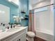 Stylish bathroom featuring a white vanity, a colorful shower curtain, and teal-painted walls at 7748 Four Seasons Blvd, Kissimmee, FL 34747