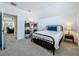 Cozy bedroom featuring neutral carpeting, a metal bedframe, and a decorative bookshelf at 7748 Four Seasons Blvd, Kissimmee, FL 34747
