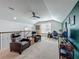 Upstairs bonus room with comfortable armchairs, a desk, entertainment area and a ceiling fan at 7748 Four Seasons Blvd, Kissimmee, FL 34747