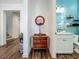 Bright hallway leading to a bathroom featuring wood-look floors and a decorative vase on a table at 7748 Four Seasons Blvd, Kissimmee, FL 34747