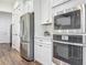 Modern kitchen showcasing stainless steel appliances, white cabinetry, and stylish tile backsplash at 7748 Four Seasons Blvd, Kissimmee, FL 34747