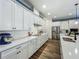 Open concept kitchen with white cabinetry, stainless appliances, and wood-look floors at 7748 Four Seasons Blvd, Kissimmee, FL 34747