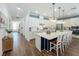 Open-concept kitchen featuring a large island with seating, white cabinetry, and wood-look tile flooring at 7748 Four Seasons Blvd, Kissimmee, FL 34747