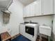 Well-equipped laundry room with washer, dryer, sink, and ample cabinet space at 7748 Four Seasons Blvd, Kissimmee, FL 34747