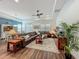 Open living room with a tray ceiling, a large brown leather sectional, and natural lighting at 7748 Four Seasons Blvd, Kissimmee, FL 34747