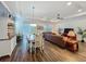 Open living room with wood floors, dining room, and leather sectional sofa at 7748 Four Seasons Blvd, Kissimmee, FL 34747