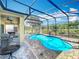 Sparkling pool in screened lanai with patio furniture and clear blue skies at 7748 Four Seasons Blvd, Kissimmee, FL 34747