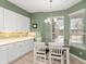 Cozy breakfast nook featuring tile floors, modern white cabinetry, granite countertops, and natural light from nearby windows at 7867 Horse Ferry Rd, Orlando, FL 32835