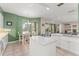 Bright eat-in kitchen featuring white cabinetry, modern granite countertops, stainless appliances, and seamless flow to living room at 7867 Horse Ferry Rd, Orlando, FL 32835