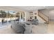 Comfortable living room showcasing neutral tones, a staircase with wood treads, and seamless transition to the outdoor pool at 7867 Horse Ferry Rd, Orlando, FL 32835