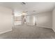 Spacious loft area featuring neutral carpeting, a ceiling fan, and a view of the staircase at 7867 Horse Ferry Rd, Orlando, FL 32835