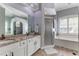 Bright bathroom with double vanity, shower, and soaking tub by a window at 8037 Bangle Ln, Orlando, FL 32836