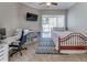 Cozy bedroom features a ceiling fan, desk, and sliding glass door to the lanai at 8037 Bangle Ln, Orlando, FL 32836