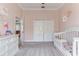 Charming Bedroom showcasing soft pink walls, plush carpeting, and a classic white crib at 8037 Bangle Ln, Orlando, FL 32836