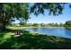 Scenic view of community pond with fountain, bench, and mature trees at 8037 Bangle Ln, Orlando, FL 32836