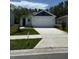 Charming single-story home featuring a two-car garage and a well-maintained front yard with green grass at 976 Commons Way, Port Orange, FL 32129