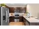 Modern kitchen with stainless steel appliances, dark cabinetry, and white backsplash at 976 Commons Way, Port Orange, FL 32129