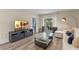 Cozy living room with a large TV, comfortable seating, and sliding glass doors to the outdoor patio at 976 Commons Way, Port Orange, FL 32129