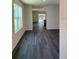 Spacious living room featuring wood-look flooring, lots of natural light, and an open concept at 976 Commons Way, Port Orange, FL 32129