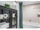 Shower/Tub area in bathroom with white tiling and a cabinet with rolled towels and plants at 1000 Winderley Pl # 140, Maitland, FL 32751