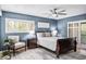 Stylish bedroom with blue walls, wood floors, plantation shutters, and comfortable furnishings at 1000 Winderley Pl # 140, Maitland, FL 32751