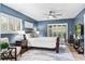 Serene bedroom featuring blue walls, wood floors, and a cozy seating area near the window at 1000 Winderley Pl # 140, Maitland, FL 32751