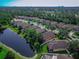 Aerial view of homes in a community, featuring lush greenery and pond with city skyline in the background at 141 Campanello Ct, Daytona Beach, FL 32117