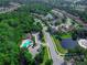 Birds eye view features a neighborhood pool and a winding road through lush trees and alongside a pond at 141 Campanello Ct, Daytona Beach, FL 32117