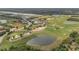 Aerial view of the golf course featuring greens, ponds, and clubhouse at 5091 Plymouth Turtle Cir, St Cloud, FL 34772