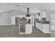 Bright kitchen with stainless appliances, island with wine cooler, mosaic backsplash, and white cabinetry at 5091 Plymouth Turtle Cir, St Cloud, FL 34772