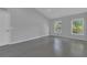 Bright living room featuring wood-look flooring and natural light from the double windows at 5091 Plymouth Turtle Cir, St Cloud, FL 34772