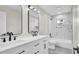 This bathroom showcases a double vanity, marble tile, and a tub-shower combination, blending luxury at 1458 Heather Way, Kissimmee, FL 34744