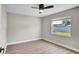 The bedroom features light walls, hardwood floors and a single window bringing in natural light at 1458 Heather Way, Kissimmee, FL 34744