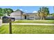Charming single-story home with stone accents, lush lawn, and mature palm trees at 1458 Heather Way, Kissimmee, FL 34744