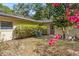A view of the home's backyard with lush green bushes, pink flowers, and well-maintained lawn at 180 Broadmoor Rd, Lake Mary, FL 32746