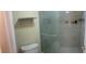 Bathroom with glass shower, tiled walls, and shelf above the toilet offers practicality and style at 200 Saint Andrews Blvd # 2306, Winter Park, FL 32792