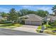 Traditional home with manicured landscaping features a three car garage and a neatly landscaped yard, adding to its charm at 2391 Northumbria Dr, Sanford, FL 32771
