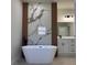 Bright bathroom featuring a modern freestanding tub and a vanity with matte black hardware at 2406 Sw 163Rd Pl, Ocala, FL 34473
