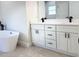 A modern bathroom features double vanities, white cabinets, and a freestanding tub at 2406 Sw 163Rd Pl, Ocala, FL 34473