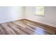 Cozy bedroom featuring wood-look flooring, white trim, and a bright window at 2406 Sw 163Rd Pl, Ocala, FL 34473