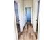 Hallway featuring wood-style floors, white trim, and doorways leading to walk-in closets and other rooms at 2406 Sw 163Rd Pl, Ocala, FL 34473