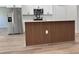 Modern kitchen island featuring wood paneling with a stainless steel refrigerator in a newly built home at 2406 Sw 163Rd Pl, Ocala, FL 34473