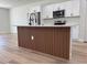 Kitchen island with wood slat accents, quartz countertop, and stainless steel appliances at 2406 Sw 163Rd Pl, Ocala, FL 34473