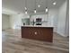 Kitchen showcasing a center island with wooden slat accents, quartz countertops, and stainless steel appliances at 2406 Sw 163Rd Pl, Ocala, FL 34473