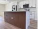 Modern kitchen island featuring wood paneling, light countertops, and stainless steel appliances at 2406 Sw 163Rd Pl, Ocala, FL 34473
