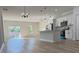 Bright, open-concept living area with a modern kitchen, stainless steel appliances, and stylish pendant lighting at 2406 Sw 163Rd Pl, Ocala, FL 34473