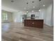 Spacious open-concept living room and kitchen area with modern light fixtures and wood-look flooring at 2406 Sw 163Rd Pl, Ocala, FL 34473
