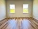 Bedroom showcasing hardwood floors, neutral walls, and natural light from two windows at 2697 Sw 165St Rd, Ocala, FL 34473