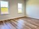 Bedroom showcasing hardwood floors, neutral walls, and natural light from two windows at 2697 Sw 165St Rd, Ocala, FL 34473