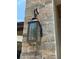 Close up of a stone exterior wall with a rustic metal outdoor light fixture at 708 Palenci Ct, Winter Springs, FL 32708
